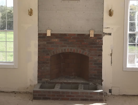 Before: solid red brick fireplace in a Lunenburg MA home, dated and flat