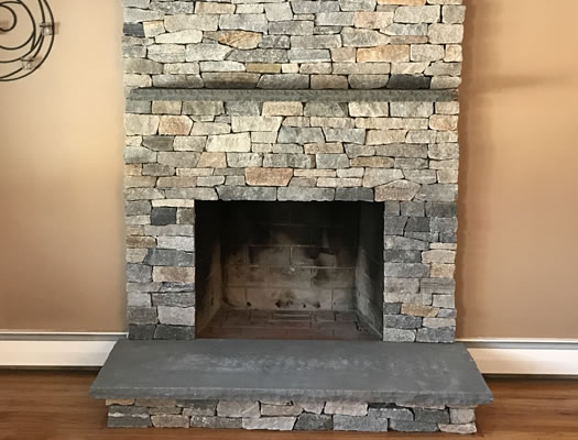 Ledgestone fireplace makeover with a bluestone hearth by JB Mohler Masonry in Massachusetts
