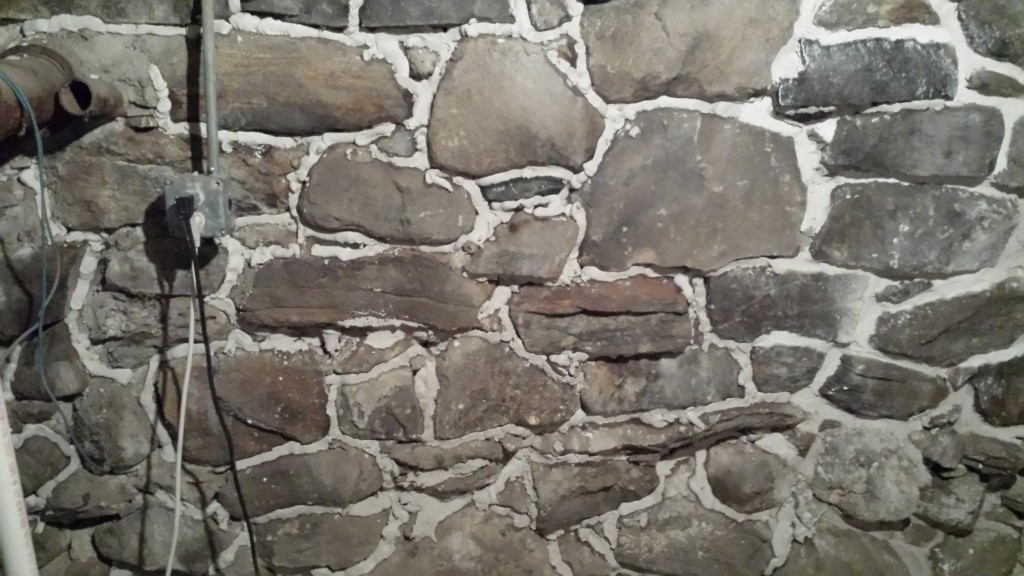 injecting lime mortar deep into stone foundation crevices